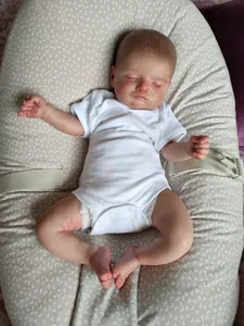 Bambola Rosalie reborn realistica da 48cm con body bianco che dorme su un cuscino