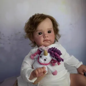 Realistic 60cm reborn baby doll with fluffy brown hair and crochet unicorn toy