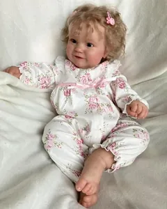 Close-up of lifelike Maddie reborn doll face with blonde curls and pink rabbit hair clip