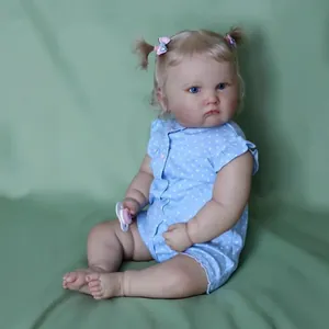 Reborn Charlotte baby doll in blue polka dot outfit with blonde hair and pink pacifier