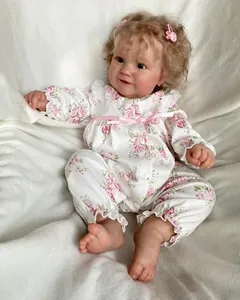 Close-up of 60cm reborn baby doll Maddie with blonde curly hair and pink bunny hair clip
