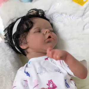 Poupée Reborn réaliste nouveau-né avec peau foncée et cheveux bouclés qui dort