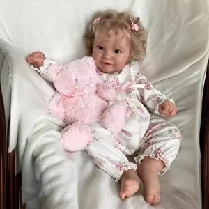 Lifelike 60cm Reborn Baby Doll Maddie with blonde curls holding a pink teddy bear