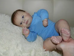 Detailed close-up of reborn baby boy Joseph with blue eyes in a light blue jumpsuit