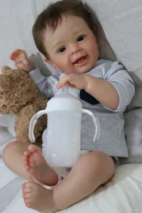 Detailansicht der 24-Zoll Reborn Babypuppe Yannik mit Teddybär und Babyflasche