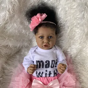 Poupée Saskia reborn réaliste de 55cm, peau foncée et tutu rose sur fond en peluche
