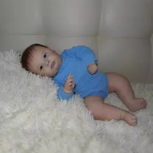 Lifelike 60cm reborn toddler Joseph doll in blue romper on white faux fur rug
