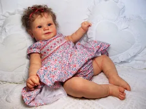 Detailed close-up of 60cm Maddie reborn doll with realistic skin and brown curly hair