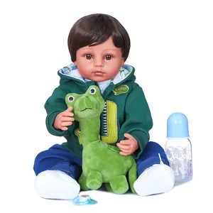 Bambola Reborn maschio 55cm con felpa verde dinosauro con peluche e accessori inclusi