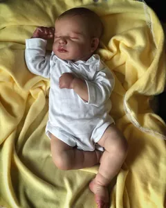 Detailed close-up of a 19 inch lifelike reborn sleeping baby doll in white romper