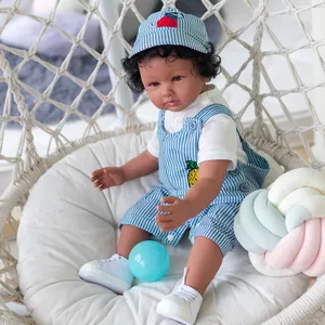 60cm Reborn boy doll with dark skin wearing blue striped overalls on a swing