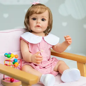 55cm realistic reborn baby girl doll in pink dress sitting on a sofa with wooden toy
