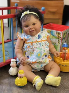 Vista detallada de muñeca Reborn de 60cm con pelo rizado y ropa floral sentada en el suelo