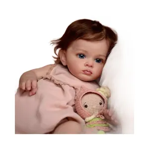 Realistic 60cm reborn toddler doll with blue eyes and pink dress holding crochet toy