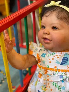 Primer plano de cara de muñeca reborn realista con vestido floral y diadema amarilla