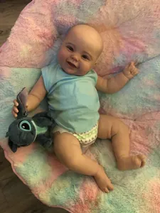 Close-up of realistic 60cm reborn baby doll with a smiling face and blue outfit