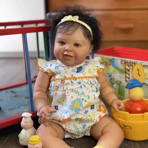 Muñeca Reborn negra de 60cm con pelo rizado y mameluco de flores en escena de juegos