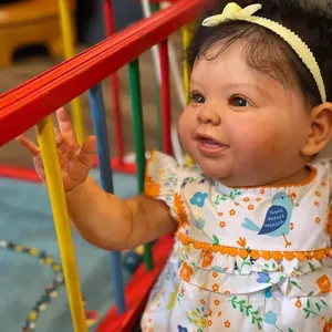 Muñeca Reborn realista de 60 cm con vestido floral junto a una valla de madera colorida