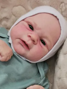 Close-up detail of Elijah reborn doll with 3D skin paint and white knit hat