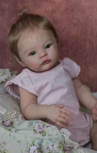 Detailed view of 18 inch realistic reborn baby doll with soft brown hair and pink outfit