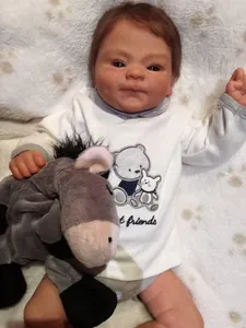Realistic 49cm reborn baby doll with white cartoon bodysuit and grey plush donkey
