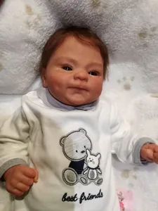 Close-up of lifelike newborn doll with realistic skin texture and bear embroidery