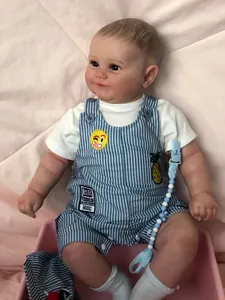 Close-up of 60cm reborn baby boy doll wearing striped overalls with pineapple patches