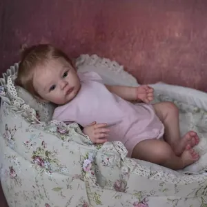 Lifelike 18-inch reborn baby doll in pink romper lying in a floral lace bassinet