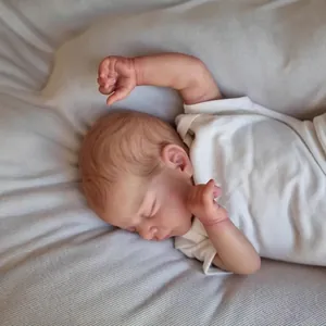 Bambola reborn realistica da 19 pollici che dorme in body bianco su tappeto morbido