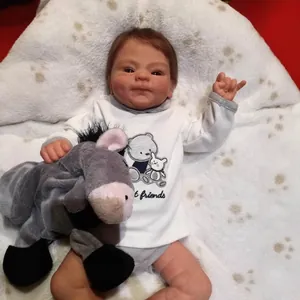 Realistic 49cm reborn baby doll in white bodysuit with small grey plush donkey toy