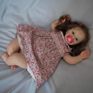 Lifelike 60cm reborn baby doll Yannik with brown hair, floral dress, and pink pacifier