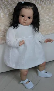 Dettaglio di una bambola reborn realistica da 60cm con vestito bianco testurizzato e scarpe