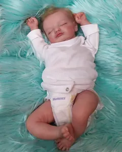 Vue détaillée de la poupée Reborn Rosalie 49cm réaliste endormie sur surface en peluche
