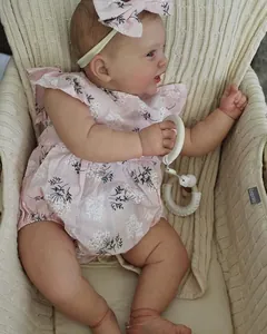 Detalle de una muñeca reborn de 60 cm con piel 3D y venas en una cesta de punto