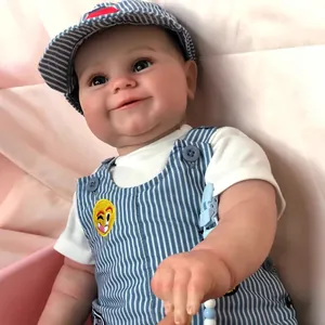 Realistic 60cm reborn baby boy doll wearing a blue striped sun hat and overall with emoji badge