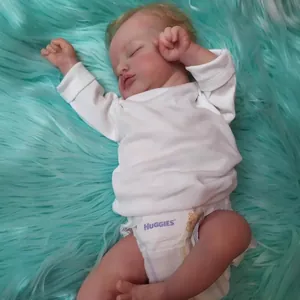 Poupée réaliste Rosalie 49cm dormant en haut blanc sur une couverture en peluche bleue