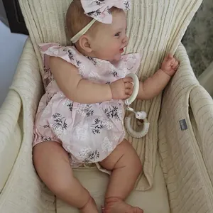 Muñeca reborn Kodi de 60cm con piel 3D y venas visibles en un conjunto de flores