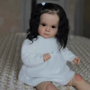 Bambola Maggi reborn realistica da 60cm con capelli neri ricci e abito in maglia bianca