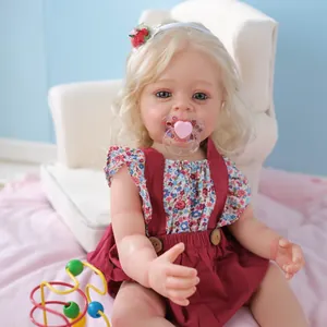 Lifelike 55cm Yannik reborn doll with 3D skin texture and red floral dress sitting on sofa