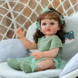 Lebensechte 55 cm Betty Reborn Babypuppe in grünem Outfit in einer weißen Hängematte
