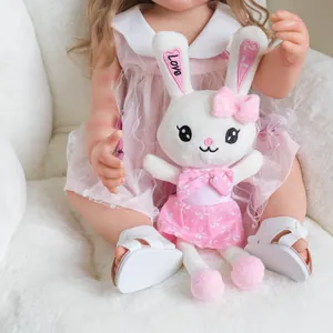 Bambola reborn Betty 55cm che tiene un coniglio di peluche con vestito a fiori rosa