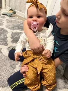 Close-up of 60cm reborn doll featuring realistic 3D skin texture and floral outfit