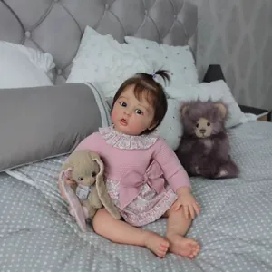 Bambola reborn realistica da 60cm in abito a fiori rosa con coniglio di peluche sul letto