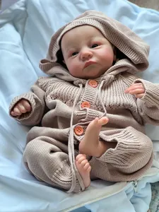 Close-up of realistic newborn doll skin texture and pink knit hooded romper with buttons