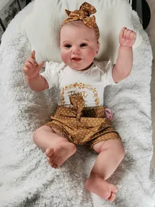 Reborn doll in white t-shirt and brown polka dot shorts with a matching headband