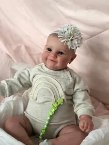 Close-up of Maddie reborn doll in grey romper with floral headband and realistic skin