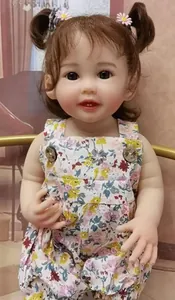 Close-up of lifelike baby doll Teegan with brown curly pigtails and floral outfit