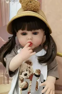 Close-up of realistic reborn baby doll features with bear-ear straw hat and cute pigtails