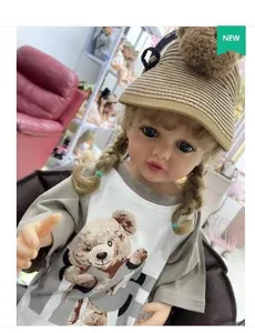 Détail d'une poupée reborn de 55cm avec tresses blondes et chapeau en paille