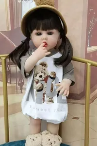 Detail of reborn baby doll in teddy bear romper and cute yellow hat in home setting